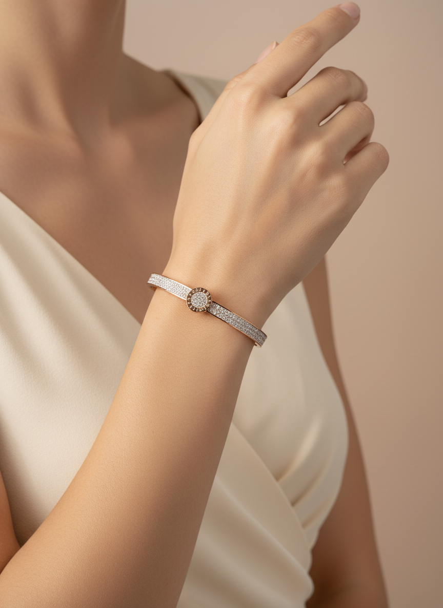 Rose gold bracelet/bangle with a decorative element on a wrist against a neutral background