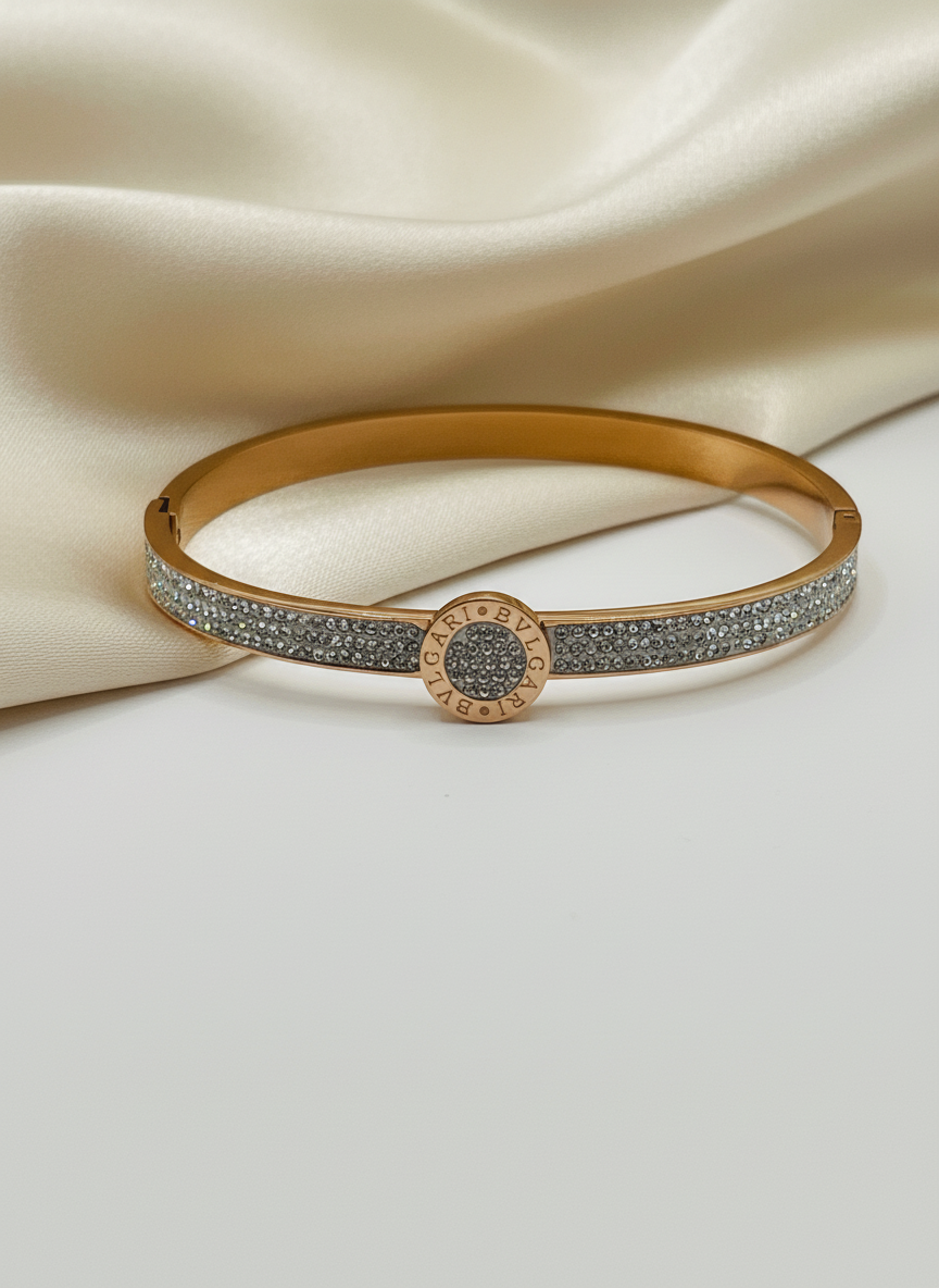 Rose Gold bracelet/bangle with diamond accents on a beige fabric background
