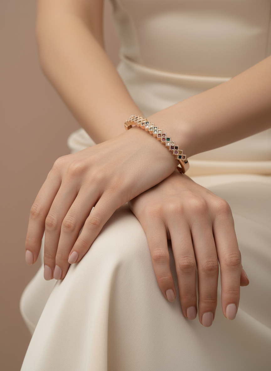 Close-up of a person wearing a rose gold bracelet on a neutral background