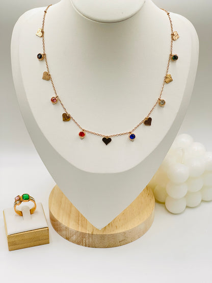 Rose gold Necklace with heart-shaped pendants on a mannequin bust, with a ring on a small stand in the foreground.