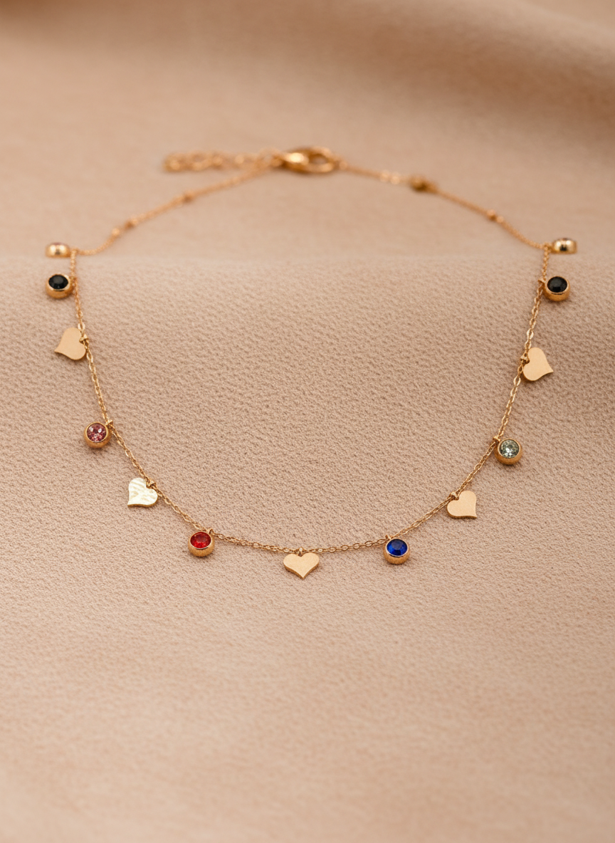 Delicate rose gold necklace with heart and gemstone charms on a beige background