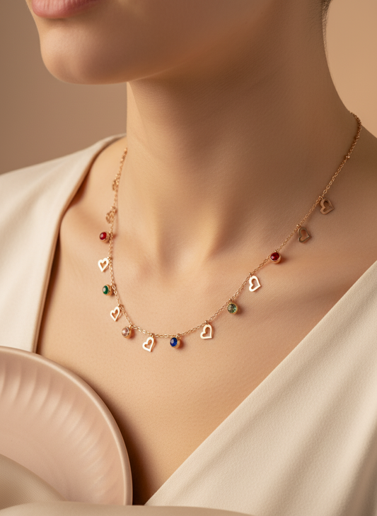 Necklace with heart-shaped charms on a mannequin bust with a ring beside it.