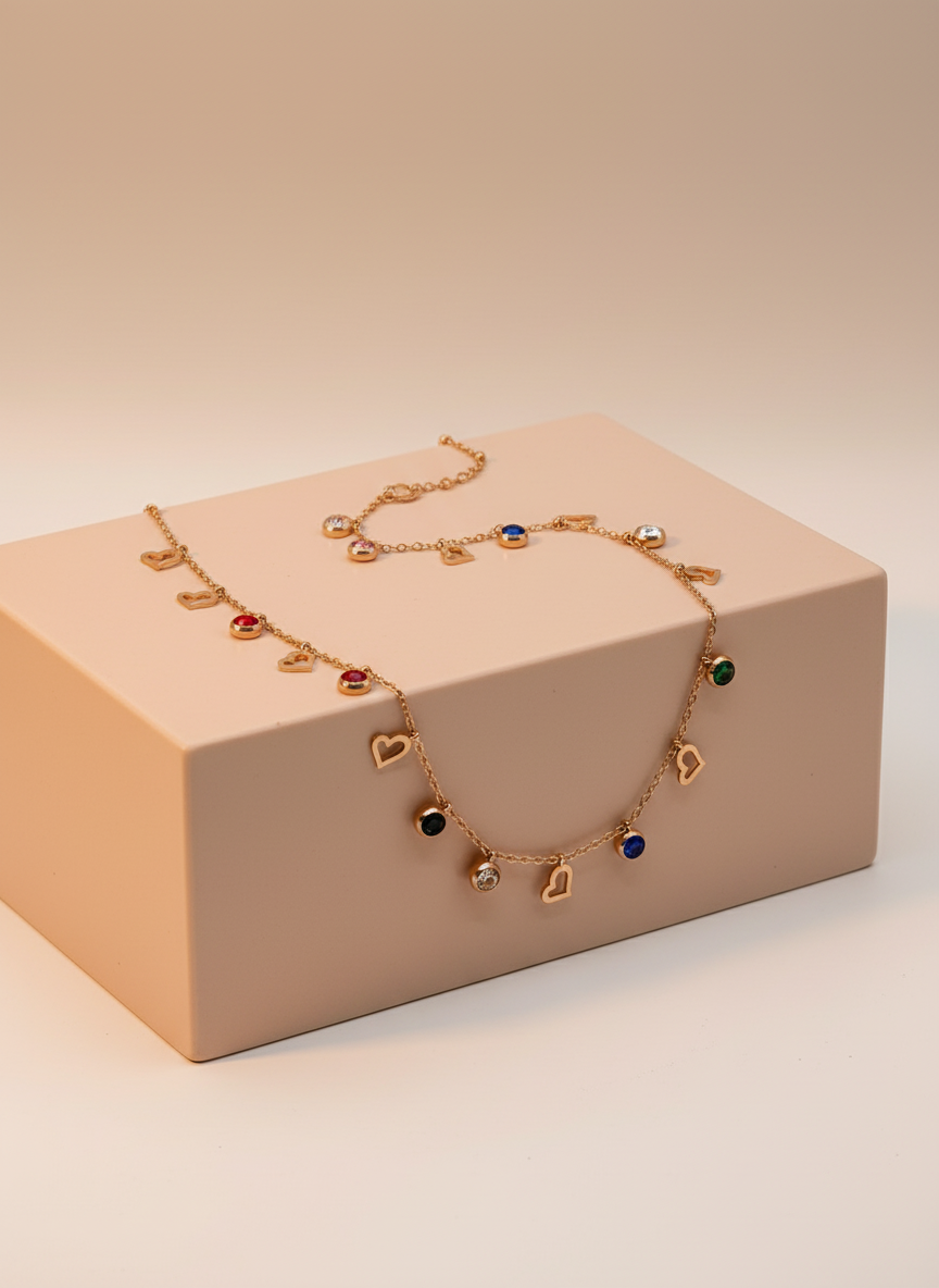 Necklace with heart-shaped charms on a mannequin bust with a ring beside it.