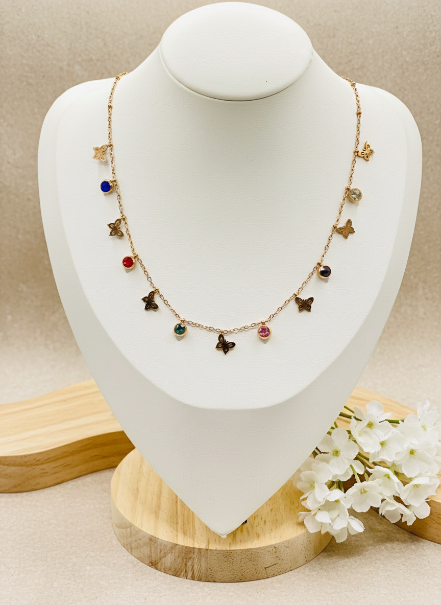 Necklace with colorful charms on a mannequin bust, accompanied by a ring on a small stand.