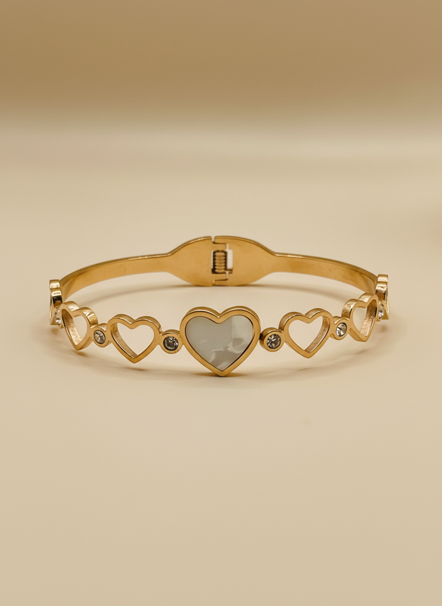 Gold bracelet with heart designs on a light gray background
