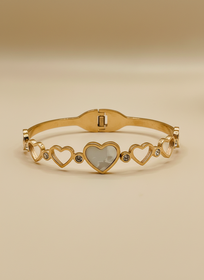 Gold bracelet with heart designs on a light gray background