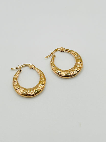 Pair of rose gold hoop earrings on a light gray background