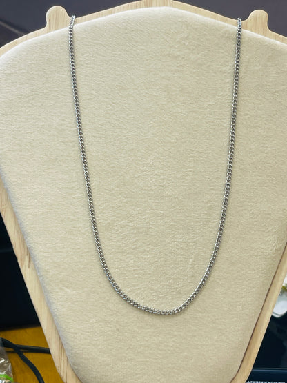 A silver-toned chain necklace draped over a beige fabric jewelry display bust.