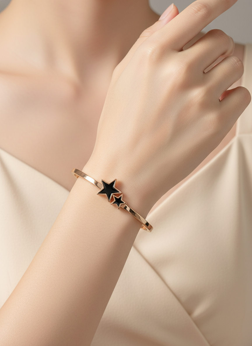 Rose gold bracelet with star design on a wrist against a neutral background
