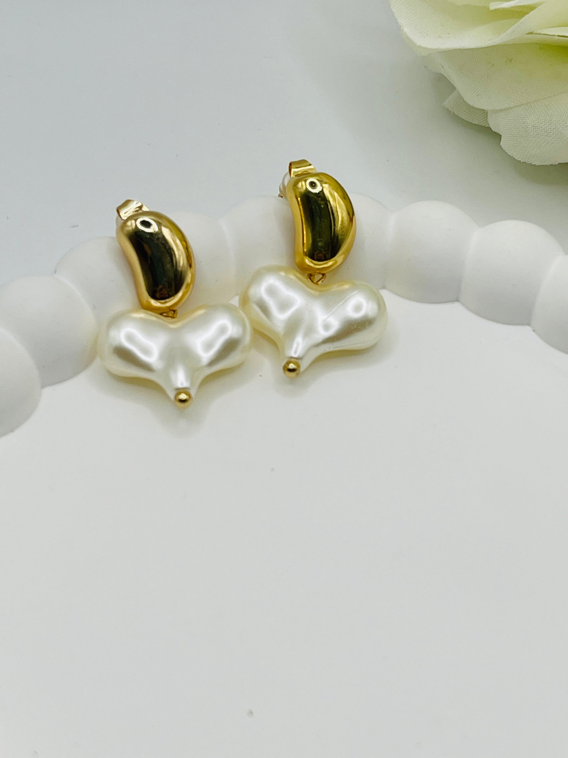 Pearl earrings with gold accents on a white surface