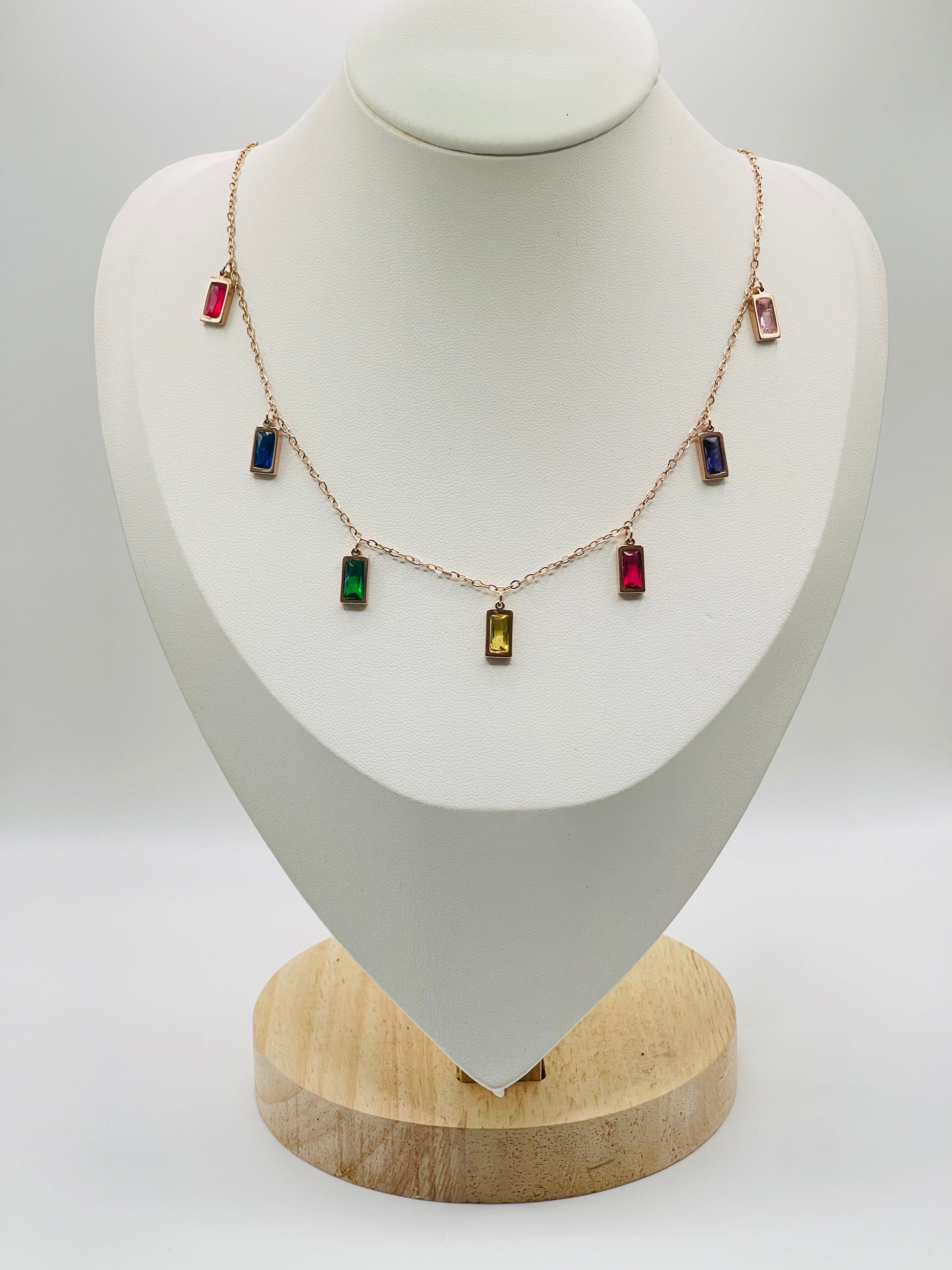 Rose goldNecklace with colorful gemstones on a mannequin bust against a white background