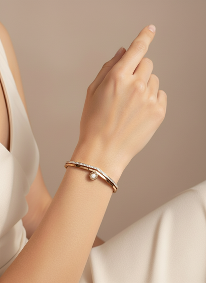 Hand wearing a rose gold bracelet on a neutral background