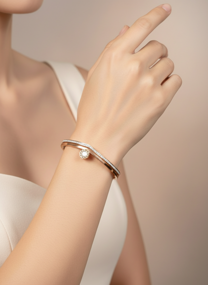Hand wearing a rose gold bracelet with a diamond on a neutral background