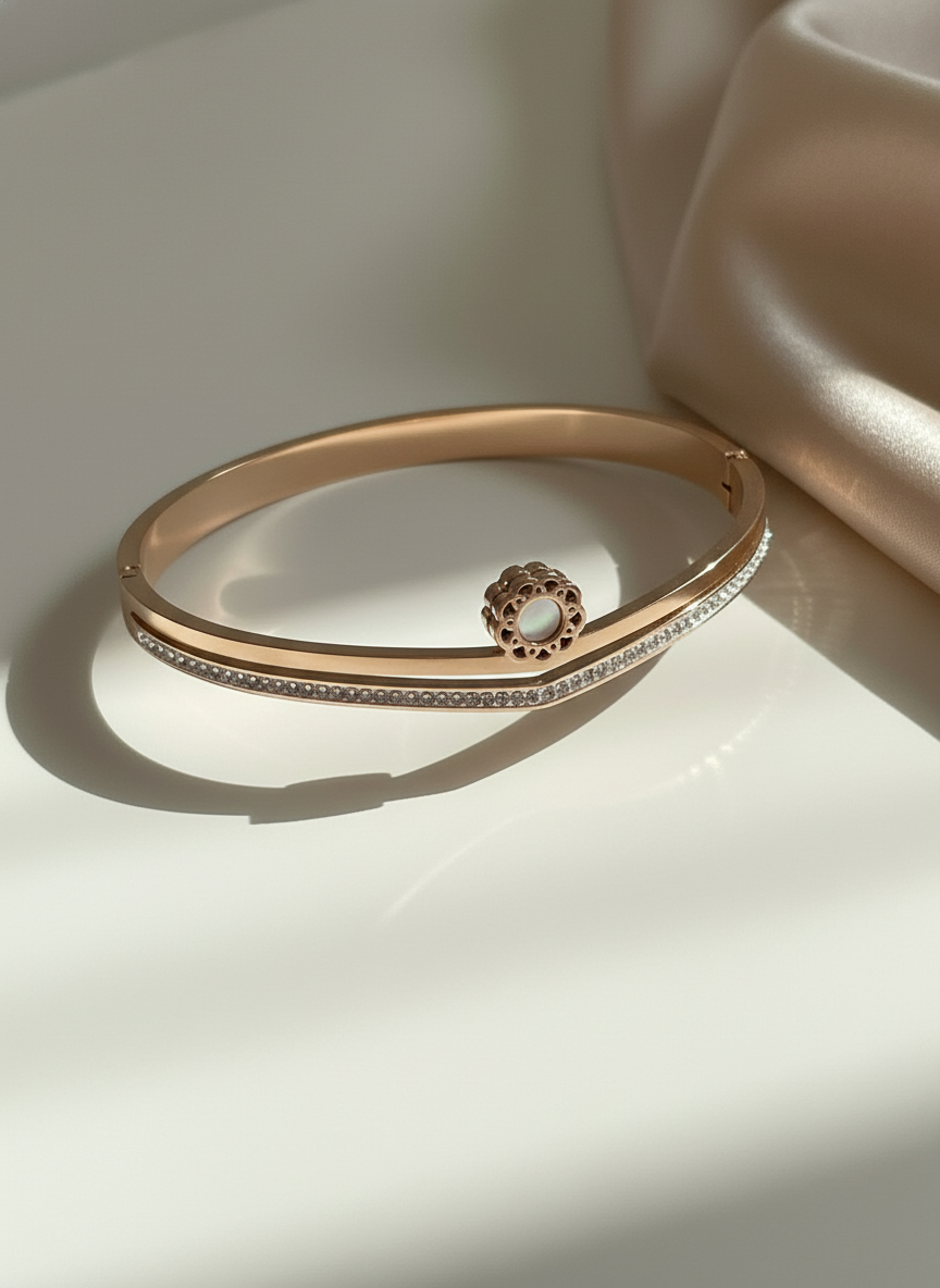 Rose gold bracelet with a decorative clasp on a light background