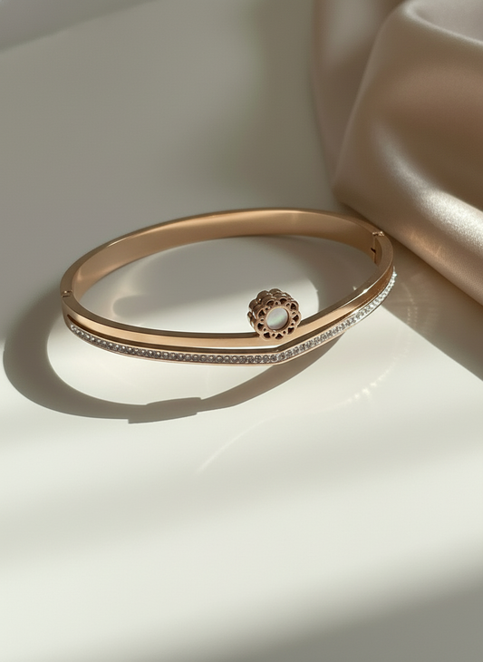 Rose gold bracelet with a decorative clasp on a light background