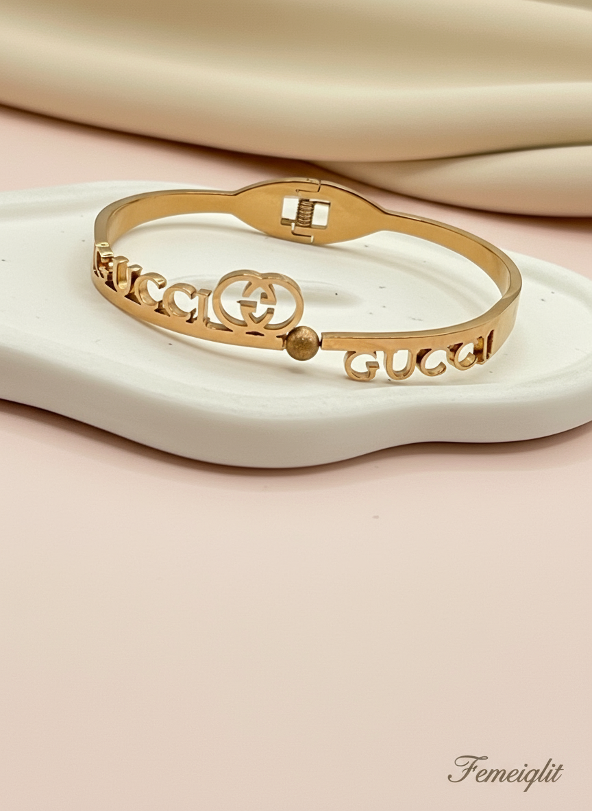 Rose Gold Gucci bracelet on a beige surface