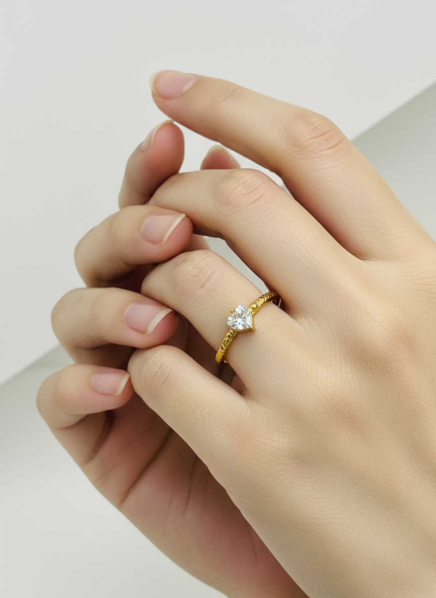 Gold ring with a diamond on a hand against a neutral background