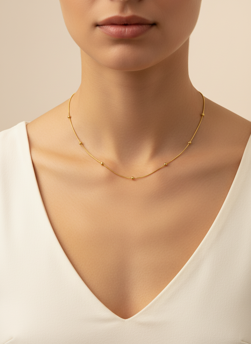 Gold necklace on a mannequin with a neutral background