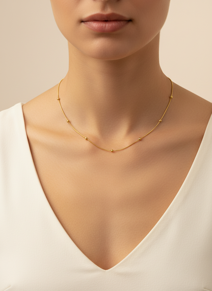 Gold necklace on a mannequin with a neutral background