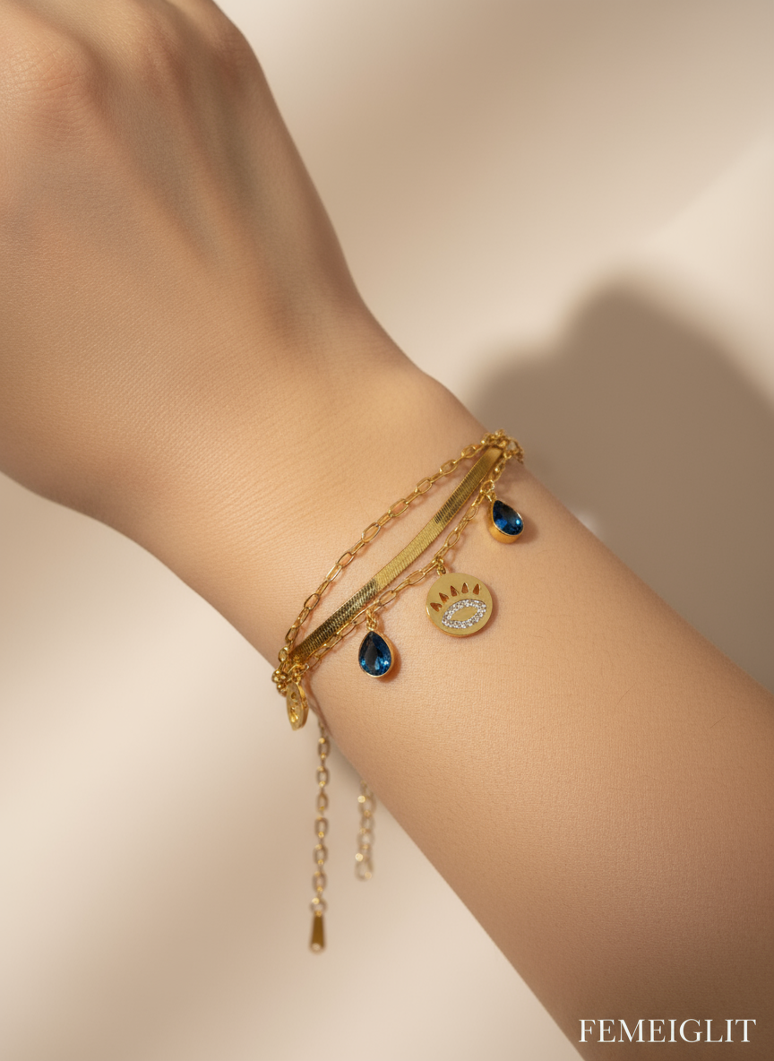Gold bracelet with blue stones on a white background