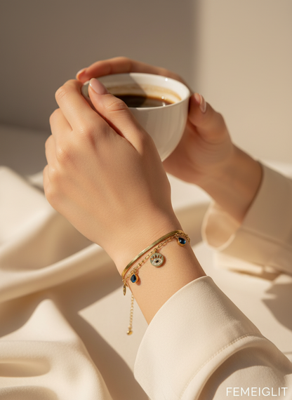 Person holding a cup of coffee with a bracelet on a neutral background