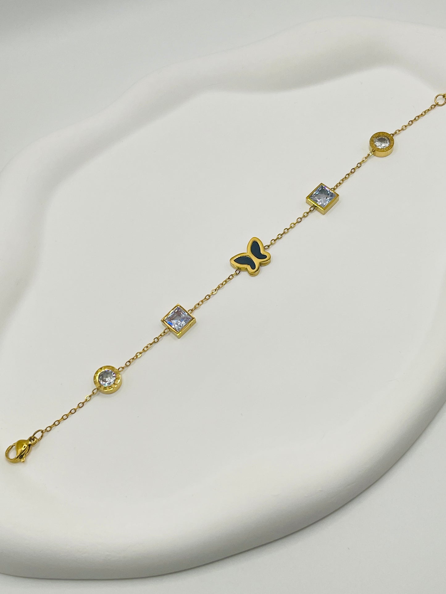 Gold bracelet with diamond-like stones on a white background