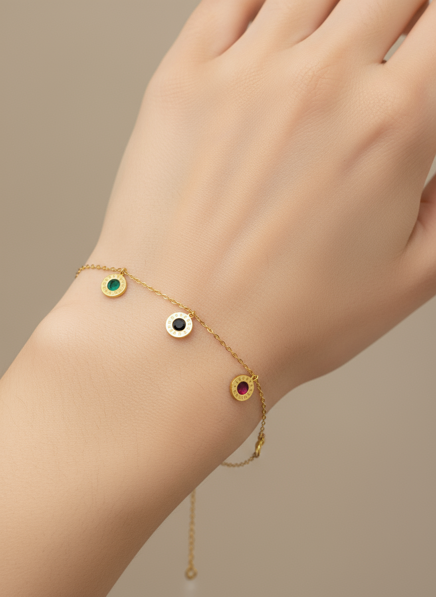 Gold bracelet with colorful gemstones on a wrist against a neutral background
