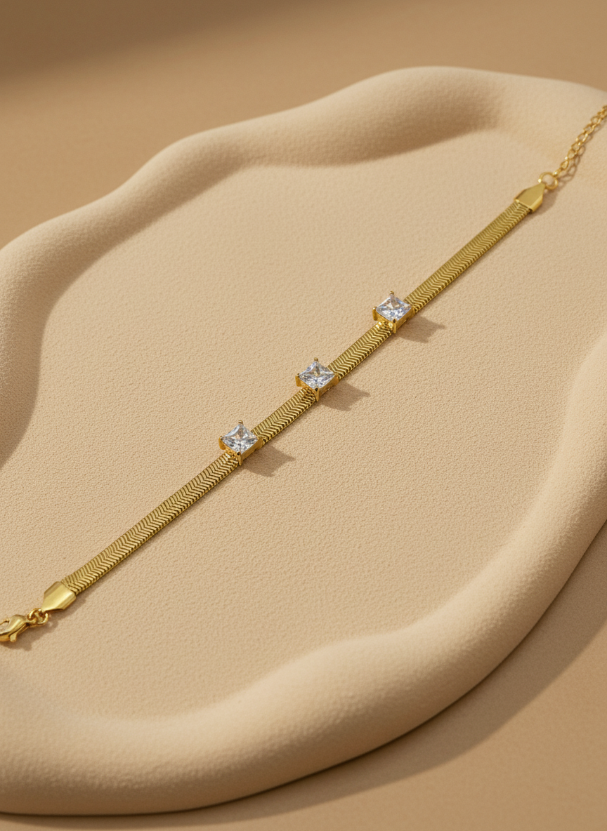 Gold bracelet with diamond-like stones on a light gray background