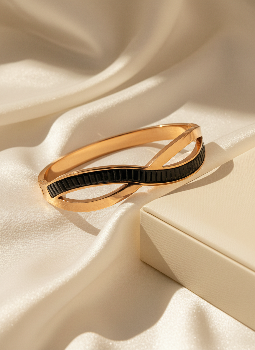 Gold and black bracelet on a beige fabric background