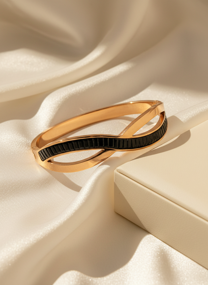 Gold and black bracelet on a beige fabric background