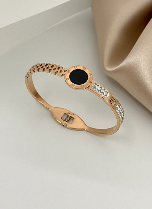 Rose gold bracelet with black gemstone and diamonds on a beige background