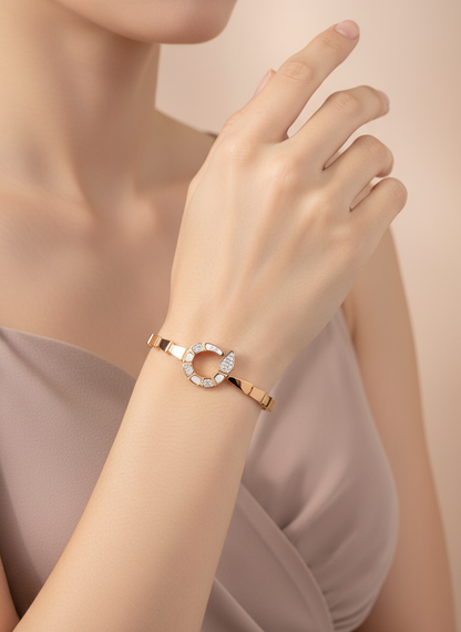 Rose gold bracelet with a diamond on a wrist against a neutral background