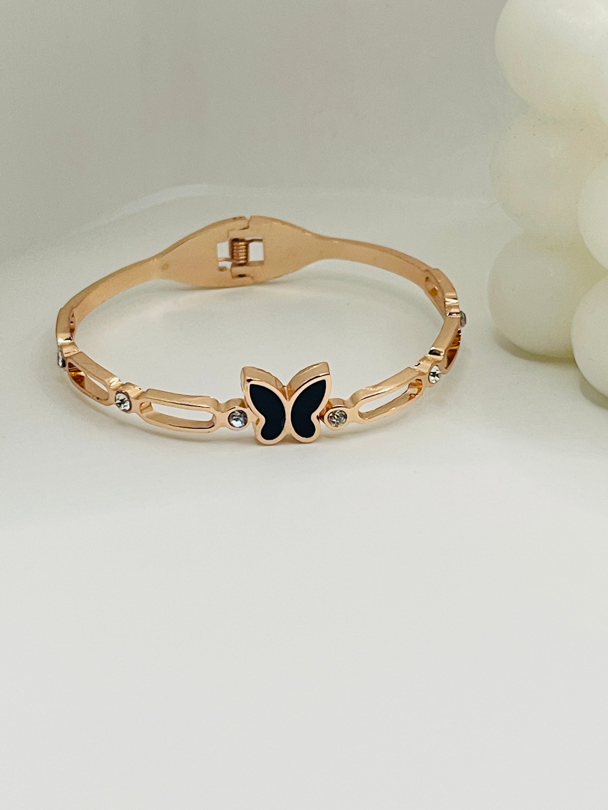 Rose Gold bracelet with a butterfly charm on a light background