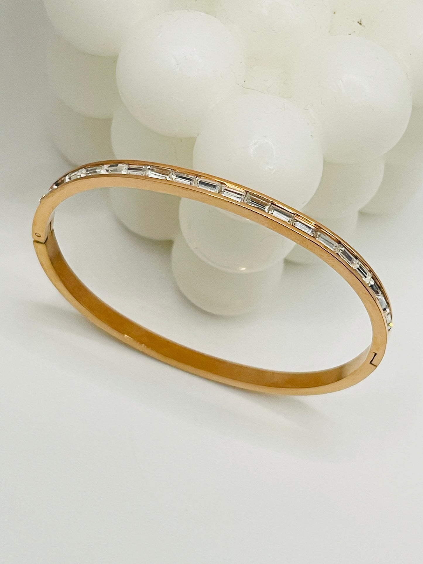 Rose Gold bracelet with embedded stones on a white background