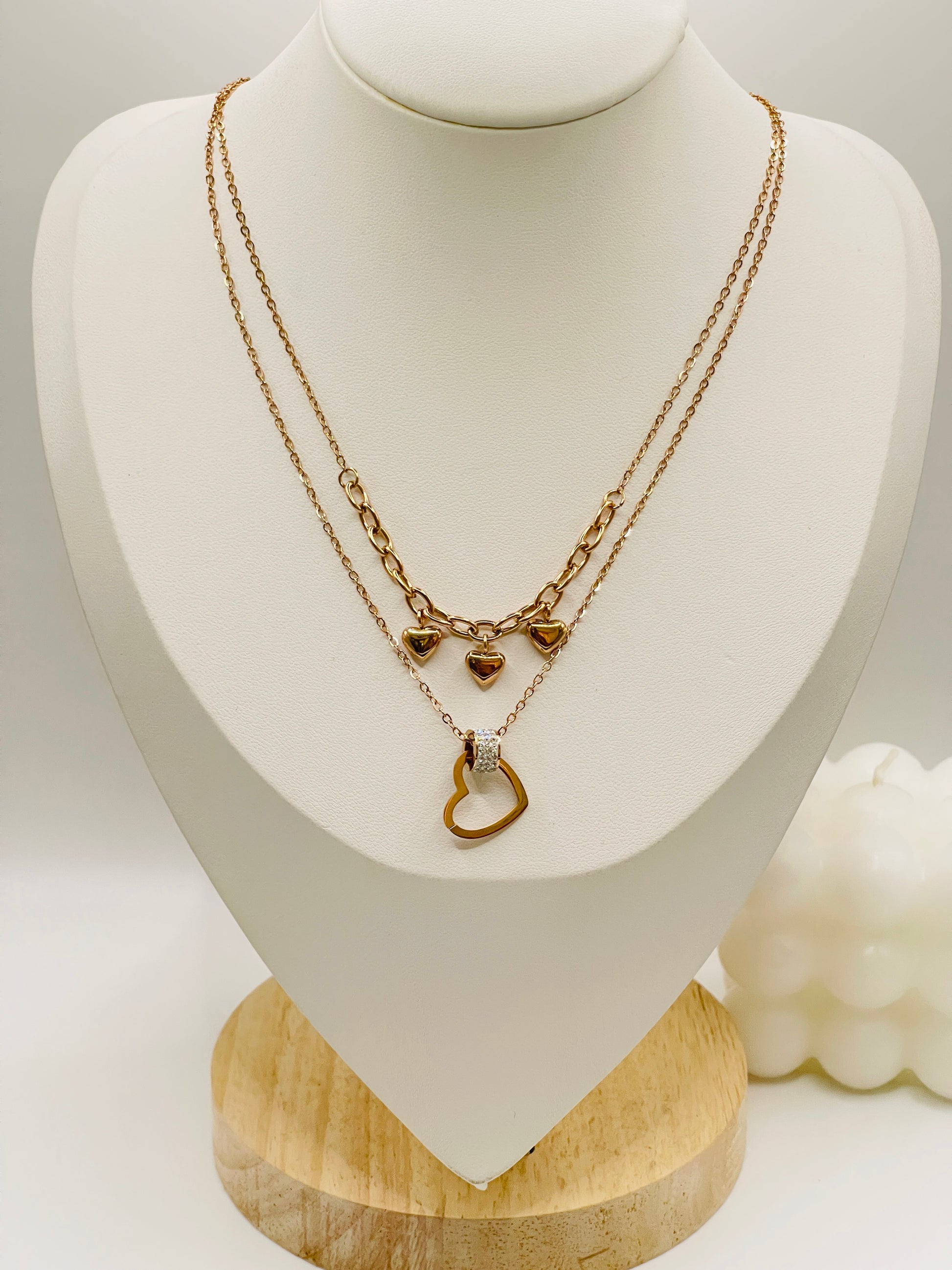 Rose Gold necklace with heart-shaped pendants on a white mannequin bust.
