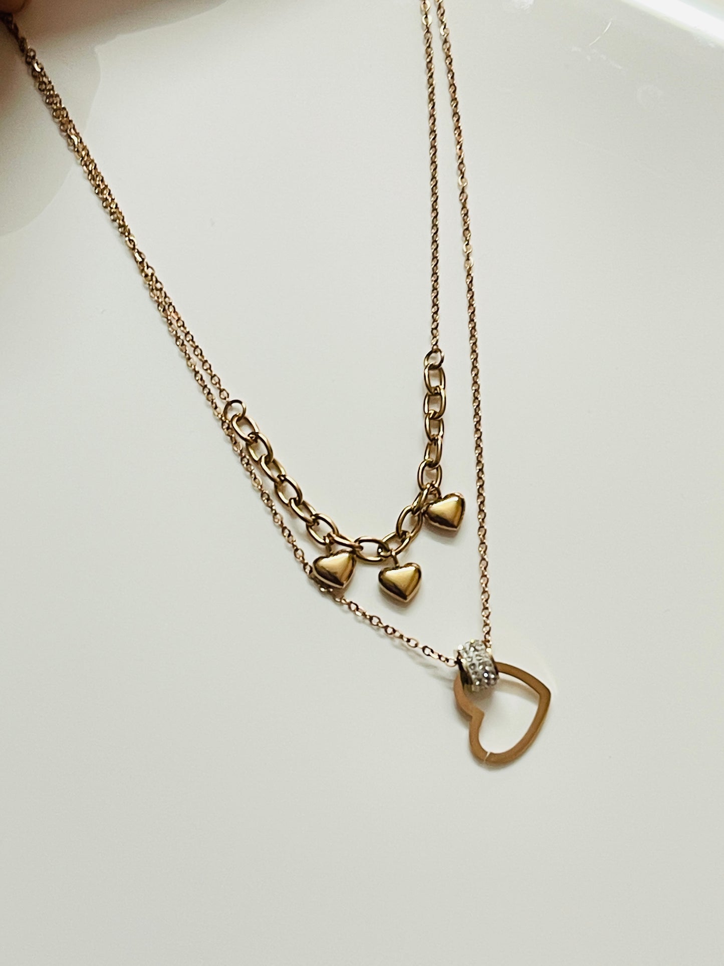 Rose Gold necklace with heart-shaped pendants on a white background