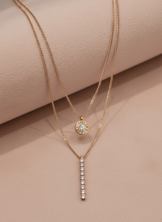Double layer rose gold necklaces with diamond pendants on a light gray background