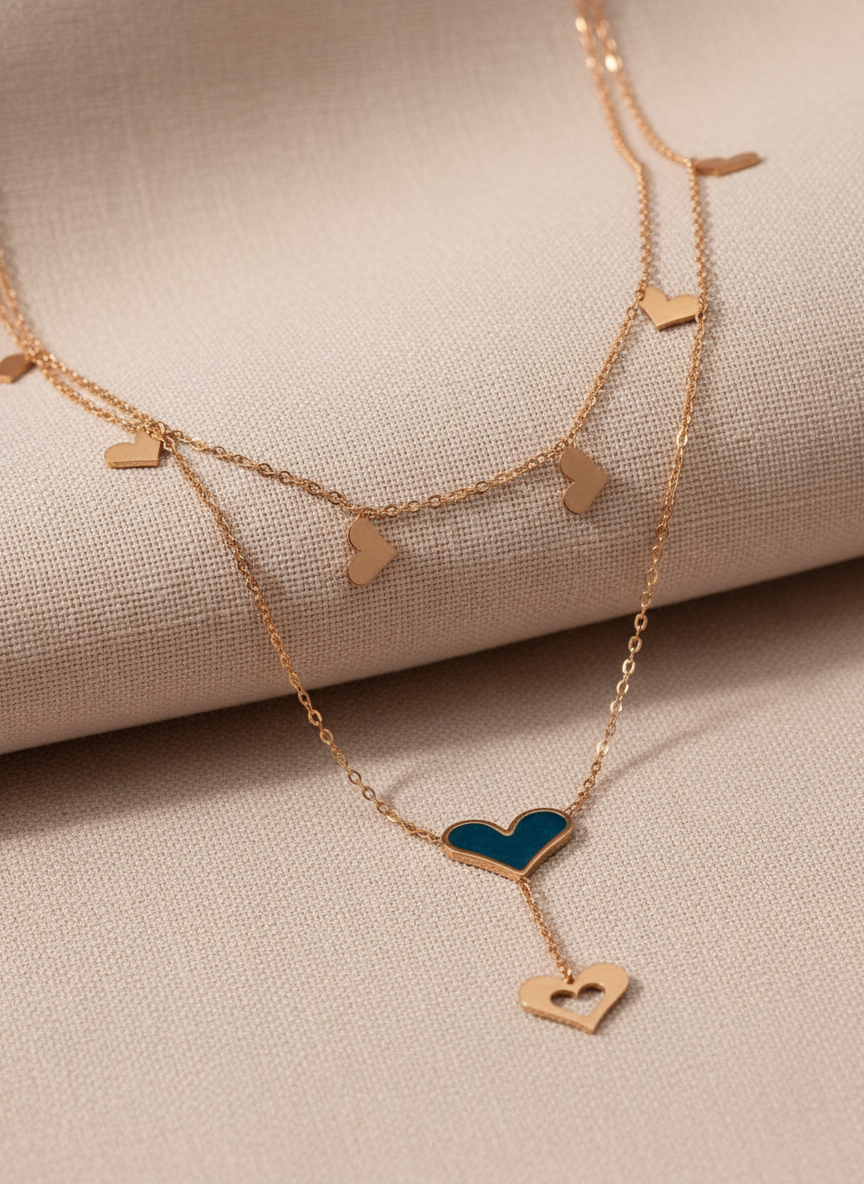 Rose Gold necklace with heart-shaped pendants on a beige fabric background