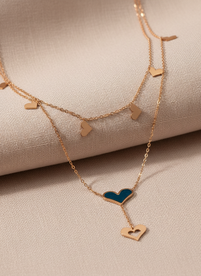 Rose Gold necklace with heart-shaped pendants on a beige fabric background