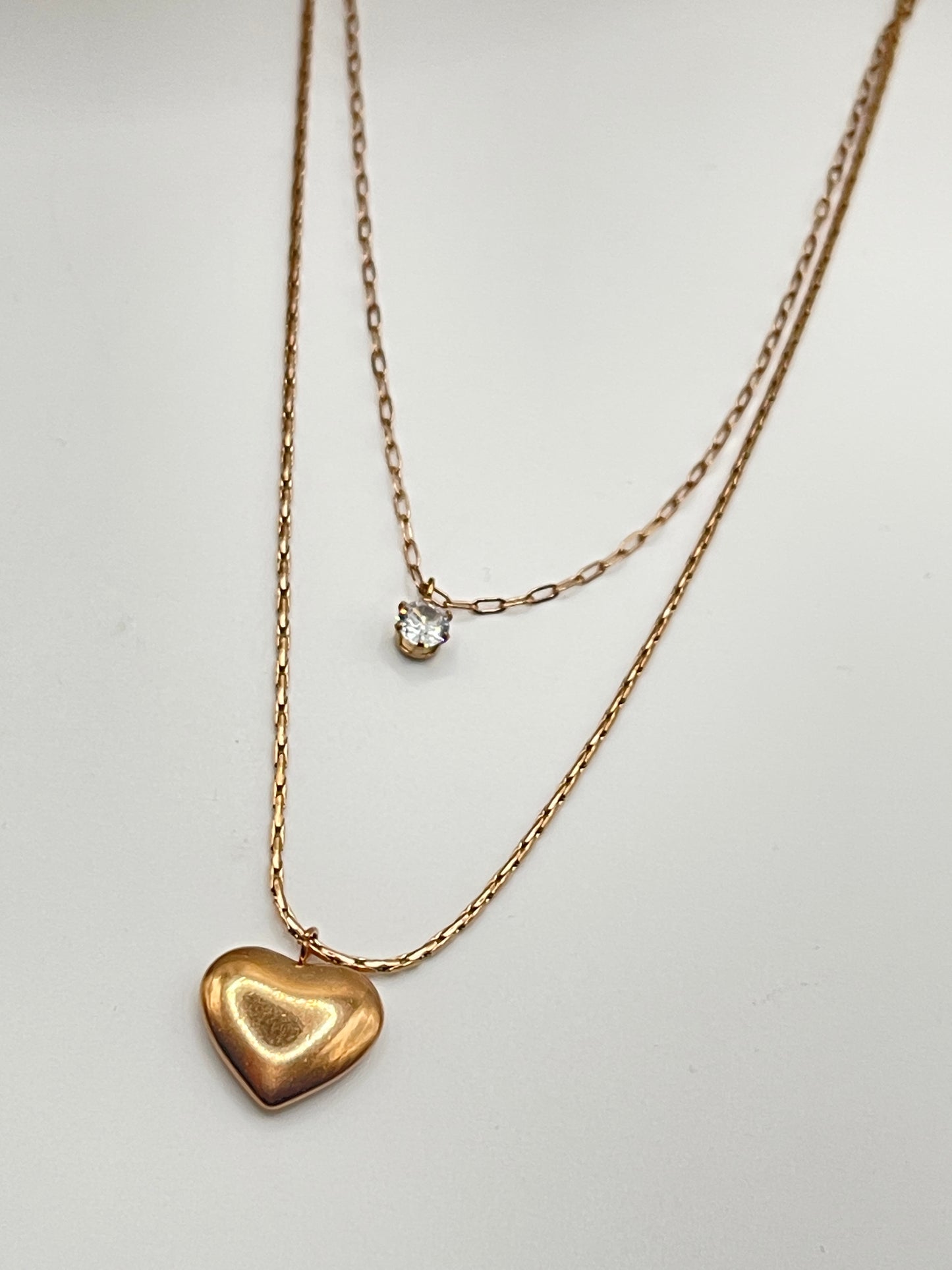 Rose Gold heart-shaped pendant necklace on a light gray background