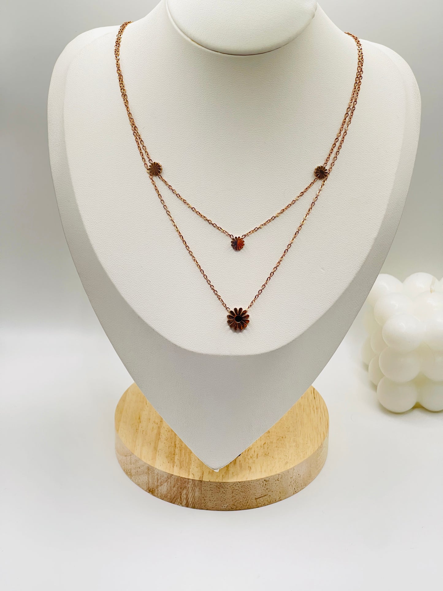 Necklace with brown stones on a white mannequin bust with a wooden base.