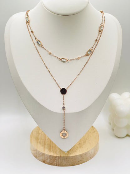 Layered rose gold necklace with black pendant on a mannequin bust.