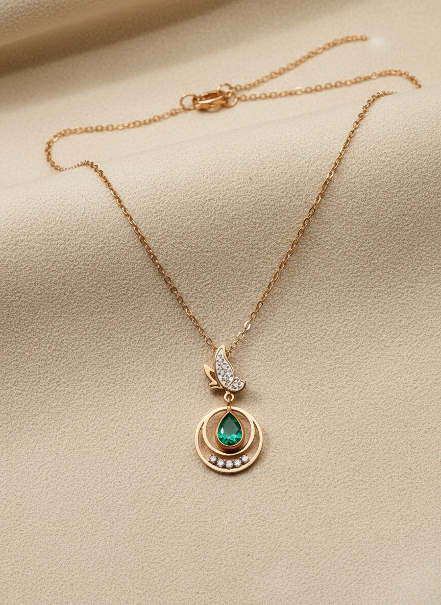 Rose Gold necklace with a green gemstone pendant on a beige background