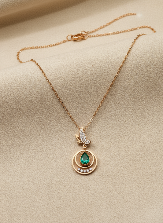 Rose Gold necklace with a green gemstone pendant on a beige background