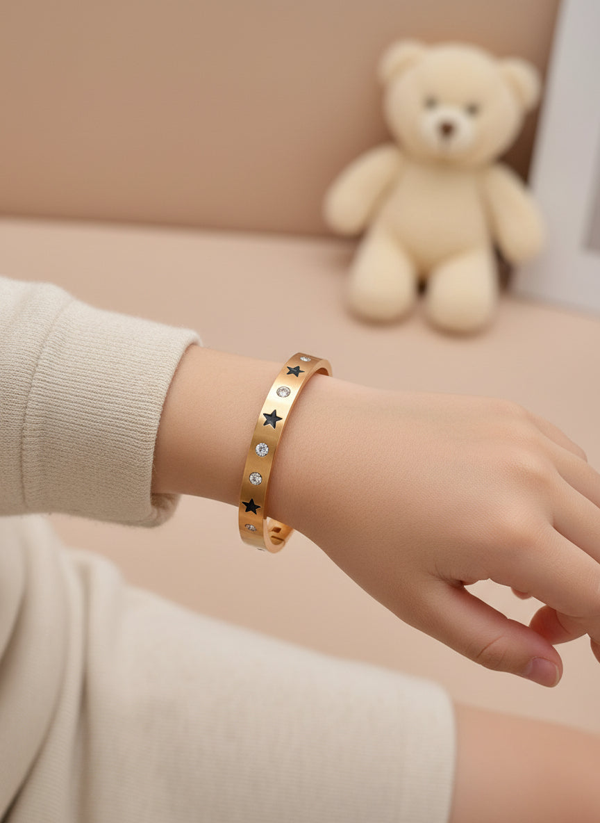 kids Rose gold bangle with star and gemstone designs on a white background