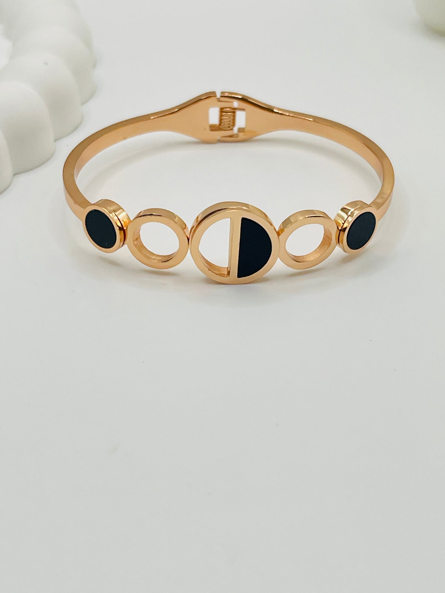 Rose Gold bracelet with black stones on a light gray background