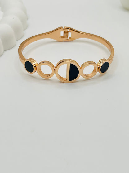 Rose Gold bracelet with black stones on a light gray background