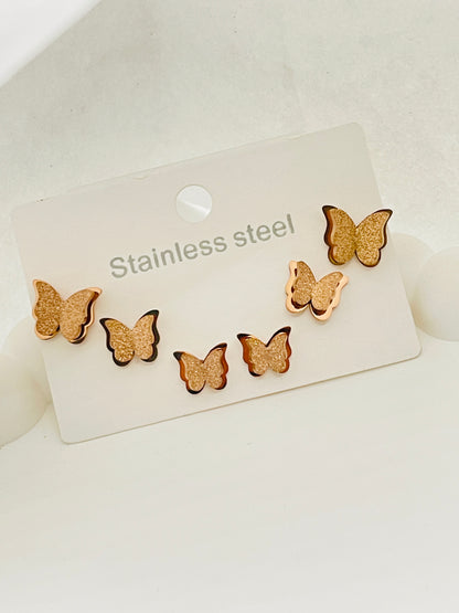 Butterfly-shaped earrings on a stainless steel card against a white background