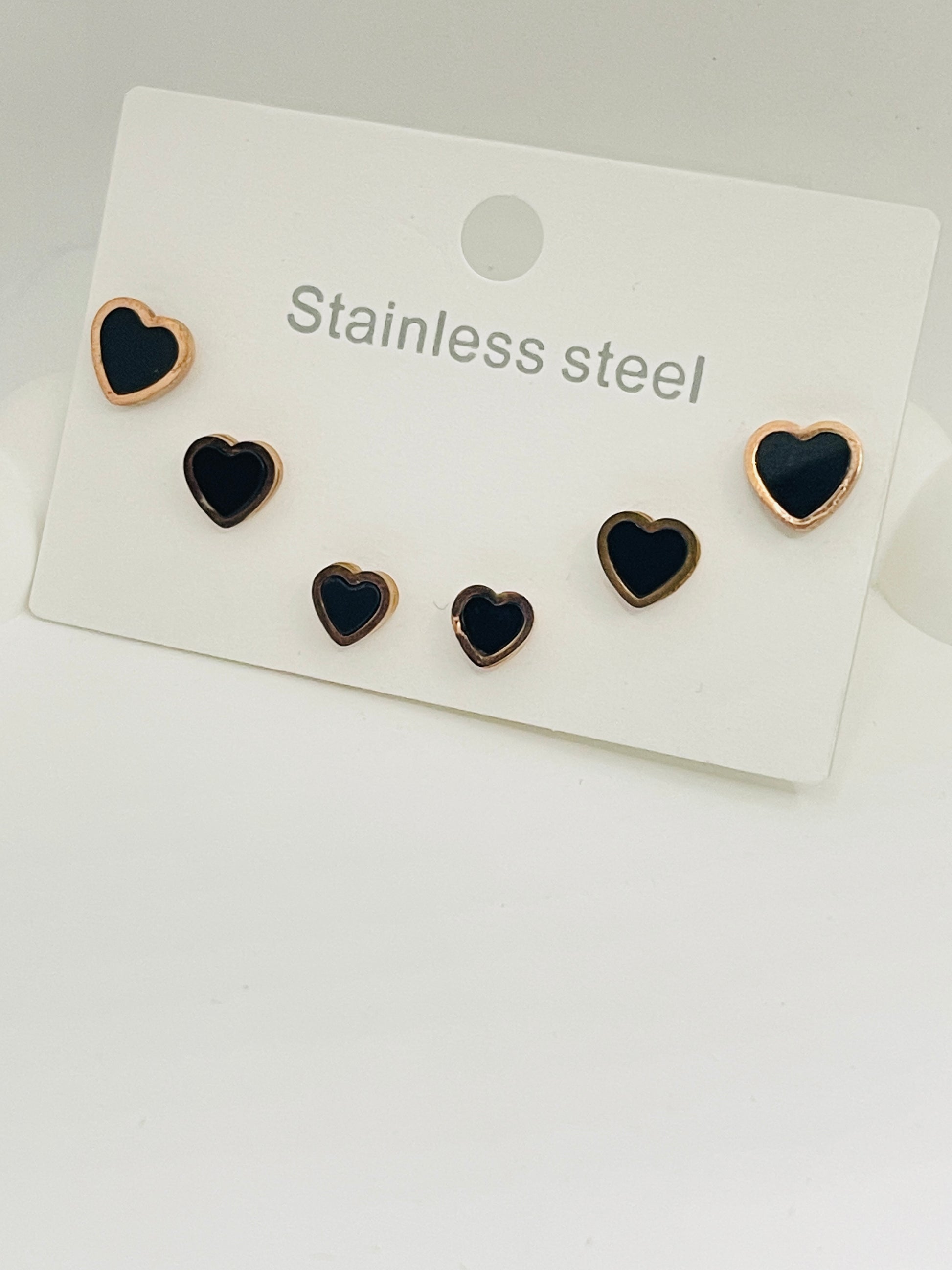 Set of heart-shaped earrings on a white card with 'Stainless steel' text.