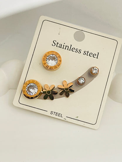 Set of stainless steel earrings on a display card with floral designs.
